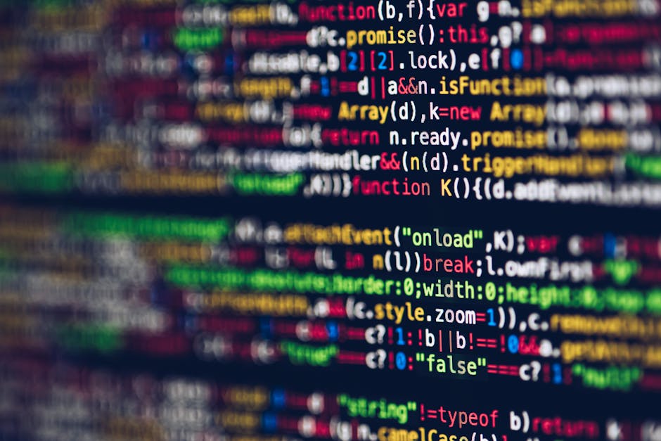 A close-up photograph of a computer screen displaying lines of colorful programming code, including syntax highlighting with keywords in red, green, blue, and yellow. The code appears to be JavaScript